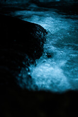 icy blue water and black rocks