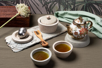 Obraz na płótnie Canvas Tea with teapot, circular cups, flowers and metal infusion basket