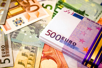 A pack of European currency lies on the background of the Euro
