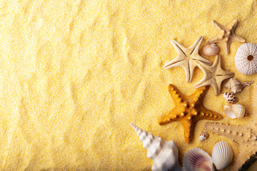 Fototapeta na wymiar Vacations and summer time concept with starfish and sea shells on a clear yellow beach sand. Sea and ocean vacation background