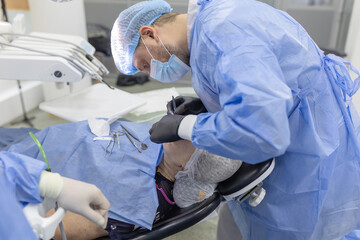 Concentrated and tense doctor surgeon dentist during dental surgery 