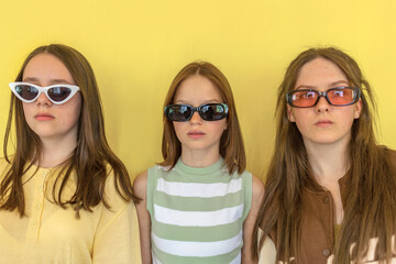 Teenagers in sunglasses on isolated yellow background