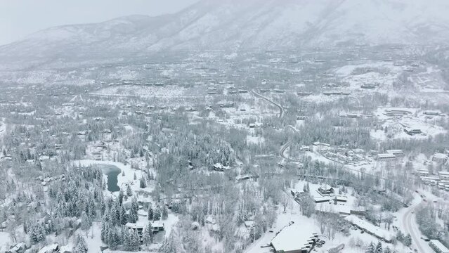 Christmas and New Year background 4K USA. Overhead view of straight streets and rooftops covered with fresh snow in small white town Colorado. Drone aerial of Aspen snowy village on cold winter day