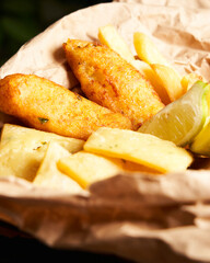 Close-up of Tasty french fries with lemon on wooden table background. Food concept