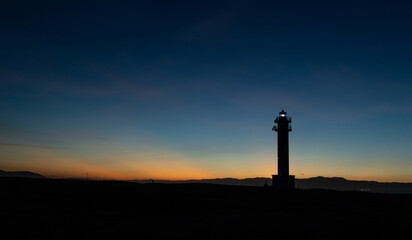 Lighthouse silhouette in Delta de l'ebro Spain during the sunset