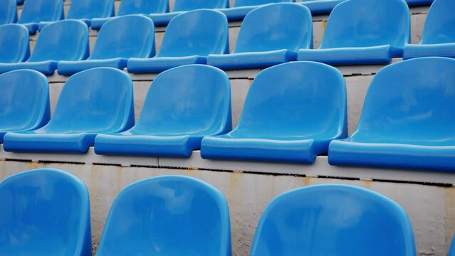 Empty bleacher in sports stadium. Blue seats in street stadium. Close up.