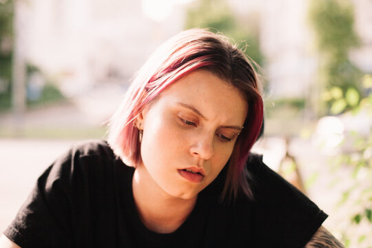 Serious young woman looking in smart phone sitting outdoors