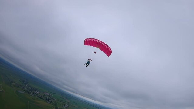 tandem parachute is landing, cloudy weather