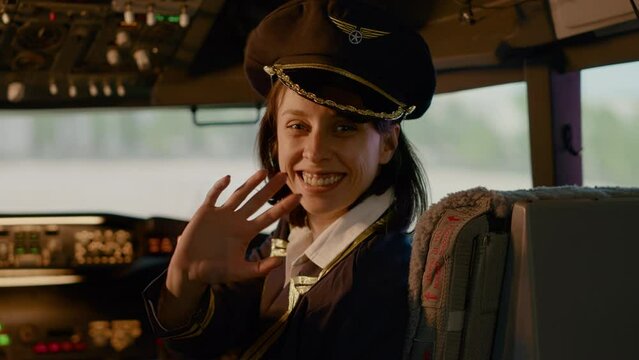 Portrait of woman airline copilot in command to fly airplane, sitting in aircraft cockpit. Using dashboard navigation compass with buttons and lever, control panel indicators.