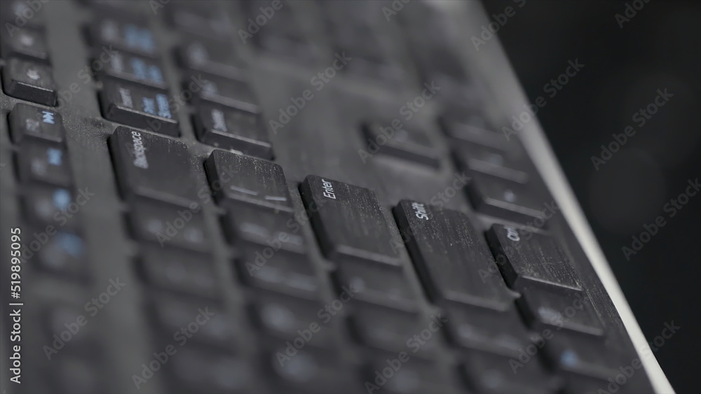 Poster close-up of finger over black laptop keys pressing enter button, computers and technologies concept.
