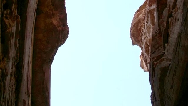View from the bottom of the canyon to the blue sky. Cleft in the rock.