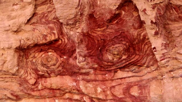 Red rock. Red eyes on the wall. Fancy abstract pattern on the rock. Stone texture