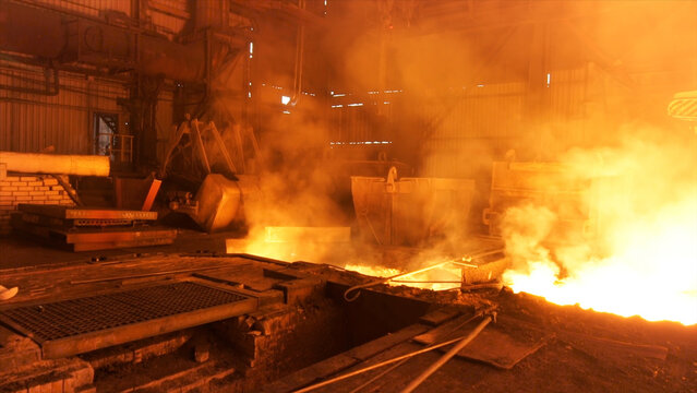 Hot shop at the metallurgical factory with molten steel in the chute. Stock footage. Metallurgical works, industrial process, iron production.