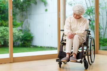 Obraz na płótnie Canvas 膝が痛い車椅子に乗った女性
