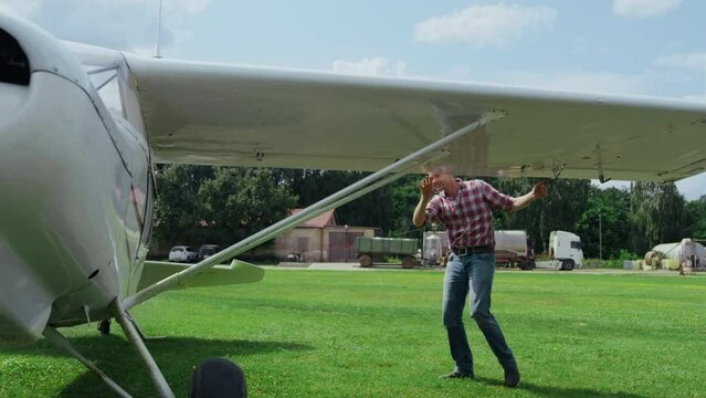 Professional pilot airplane making preflight inspection process checking wings.