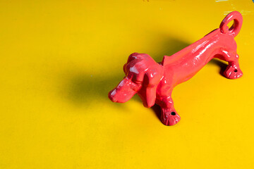Pink metal dog on mustard color