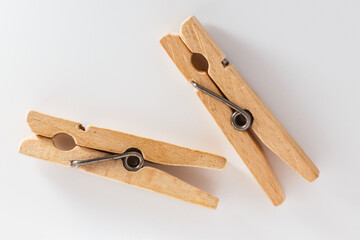 Two wooden clothespins on a white background