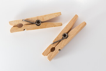Two wooden clothespins on a white background