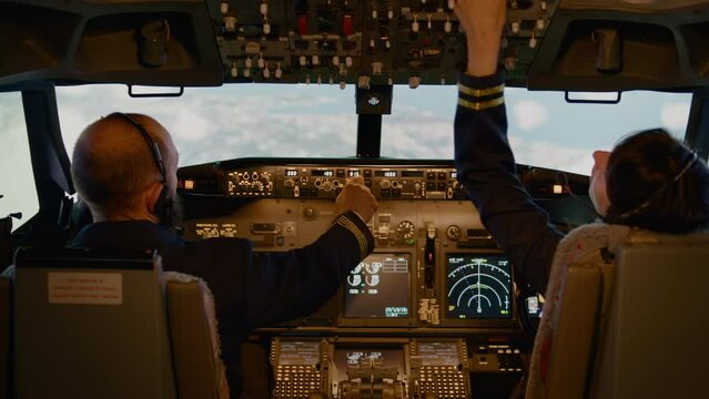 Pilot and woman copilot fixing altitude and longitude on dashboard, preparing to takeoff with engine throttle and control panel. Using cockpit command to fly airplane. Handheld shot.