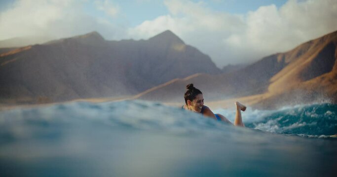 Hawaiian surfer girl paddling out at sunset on longboard, summer lifestyle, surfing in Hawaii