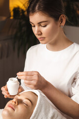 Close up portrait of cosmetologist female holding jar of mask. Beauty treatment and skin care routine. Cosmetology.