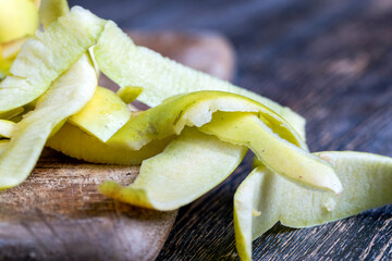 sliced and peeled green apple on a wooden board