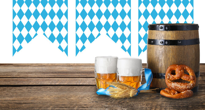 Mugs of fresh beer, pretzels and wooden barrel on table. Oktoberfest celebration
