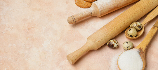 Ingredients for cookies and rolling pins on color background with space for text