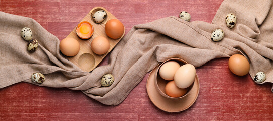 Raw chicken and quail eggs on wooden background