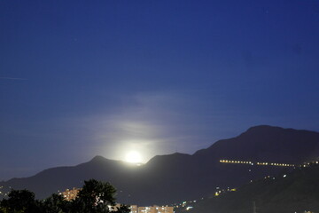 Urban view of the moon in the night sky