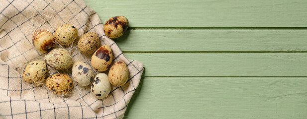 Fresh quail eggs on green wooden background with space for text