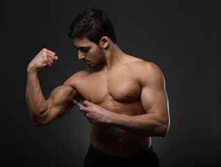 Muscular man with a syringe in his hand. User of anabolic steroids for strength training.