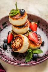 Plate with cottage cheese pancakes, fresh berries and mint leaves, closeup