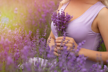 
Young woman holding bouquet of lavender flowers in field
