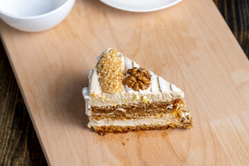 a piece of cake with buttercream and walnuts