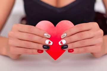 
Beautiful female hands with romantic manicure nails, holding red heart, Valentine's day design
