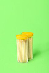 Holders with toothpicks on green background