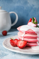 Plate of tasty pink pancakes with strawberry and sauce on color background, closeup