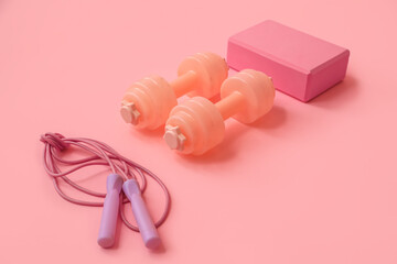 Set of sports equipment on pink background