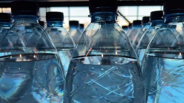Mineral water in two liter plastic bottles stand on supermarket shelves or warehouse. Close-up shot