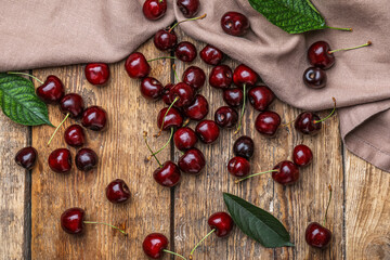 Scattered ripe cherries on wooden background