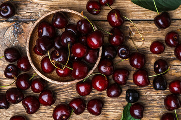 Bowl with cherries on wooden table
