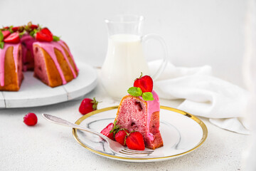 Plate with piece of strawberry cake on light table