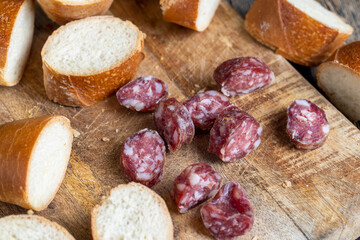 sausage sliced with a baguette on a wooden board