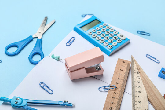 Stapler With Different Stationery Supplies On Blue Background