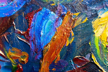 Multicolored large strokes of oil paint in blue, red and yellow shades on canvas, close up....