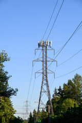 Mobility antennas installed on a power line transmission tower, warm evening light against a blue...