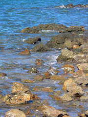 Beach scene with the ocean washing up on rocks