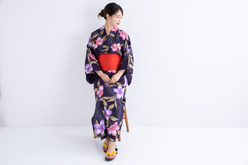 Obraz na płótnie Canvas 浴衣を着て椅子に腰掛ける女性　Japan 