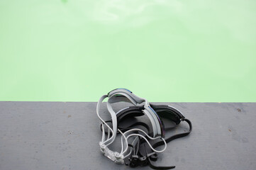 Two waterproof goggles, they are placed on the edge of the pool.